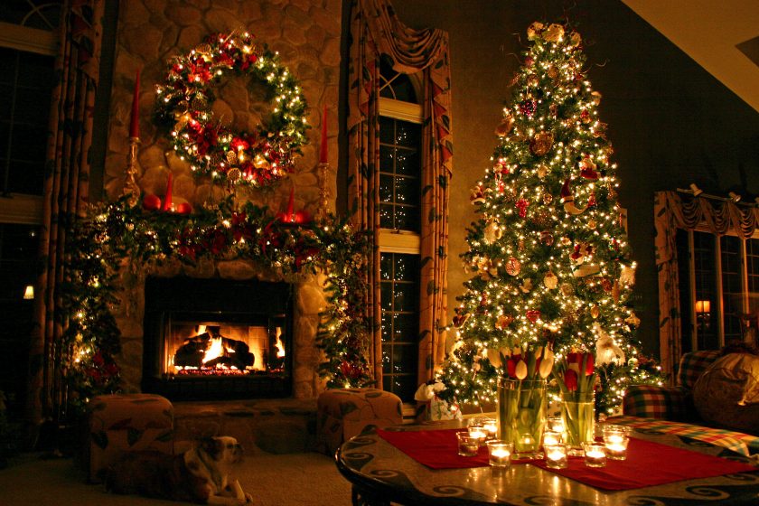 Đêm Noel với lò sưởi ấm áp và cây thông trang trí đèn màu lấp lánh
