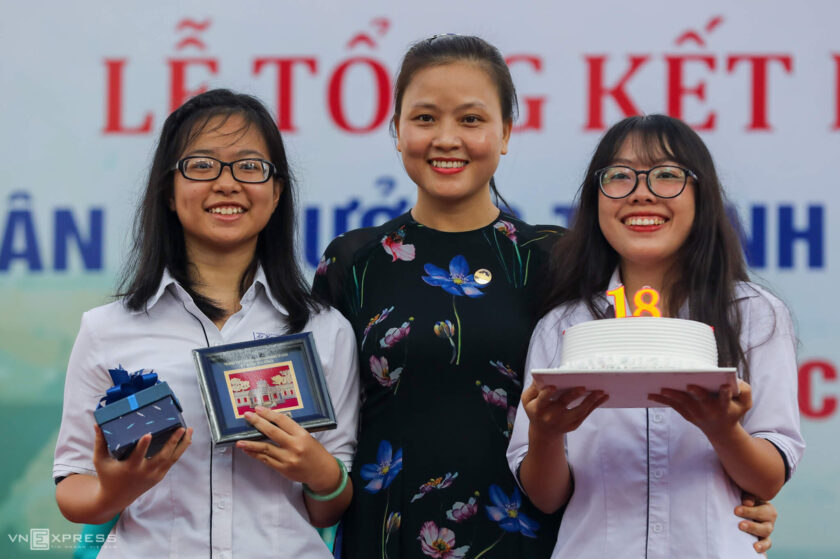 hình ảnh cô giáo và học sinh cùng nhận thưởng