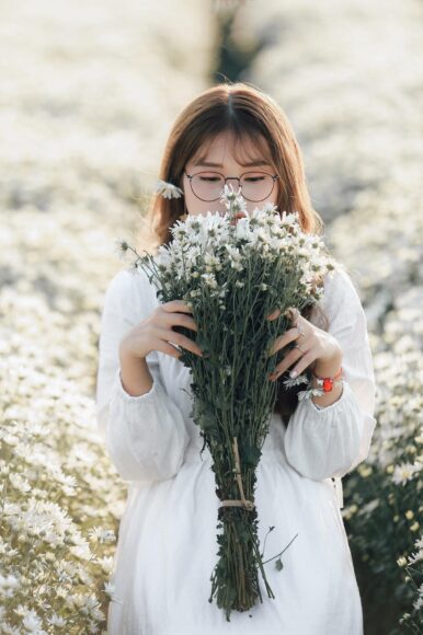 Ảnh cô gái cầm hoa che mặt