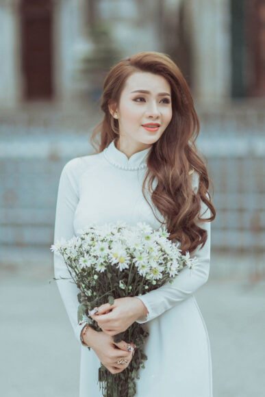 Ảnh cô gái cầm hoa mặc áo dài