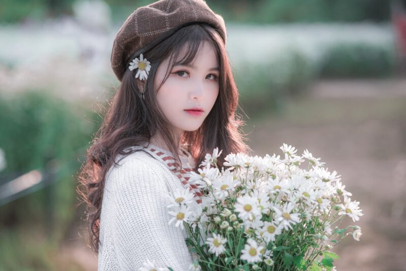Hình ảnh cô gái cầm hoa đội mũ cực xinh