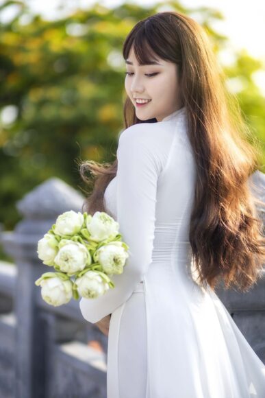 Hình ảnh cô gái cầm hoa thướt tha trong bộ áo dài trắng