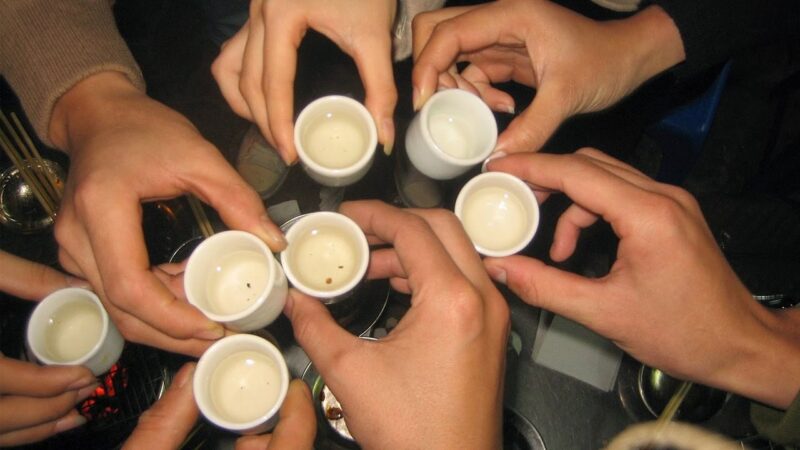 Hình ảnh tay cầm chén rượu