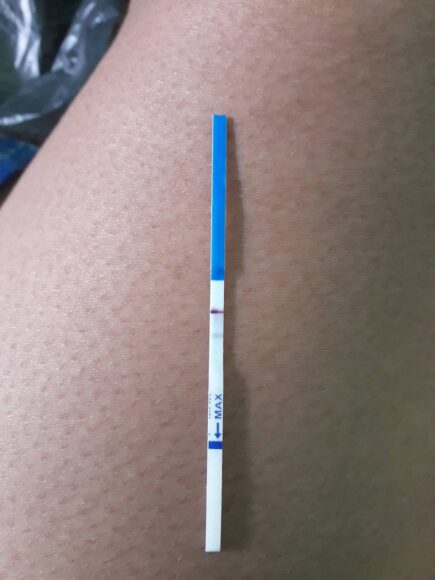 hình ảnh que thử thai 2 vạch để trên đùi