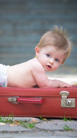 Ảnh bé trai cute nằm trên chiếc vali