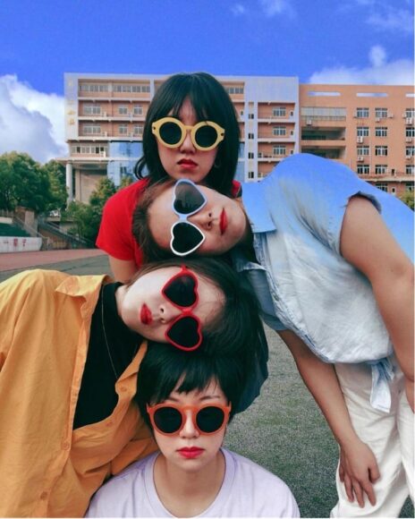 Hình ảnh nhóm bạn thân đeo kính hình tròn và trái tim chụp ảnh