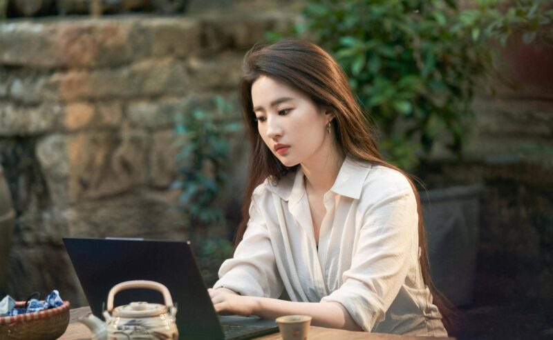 hình ảnh Lưu Diệc Phi ngồi làm việc trên máy tính